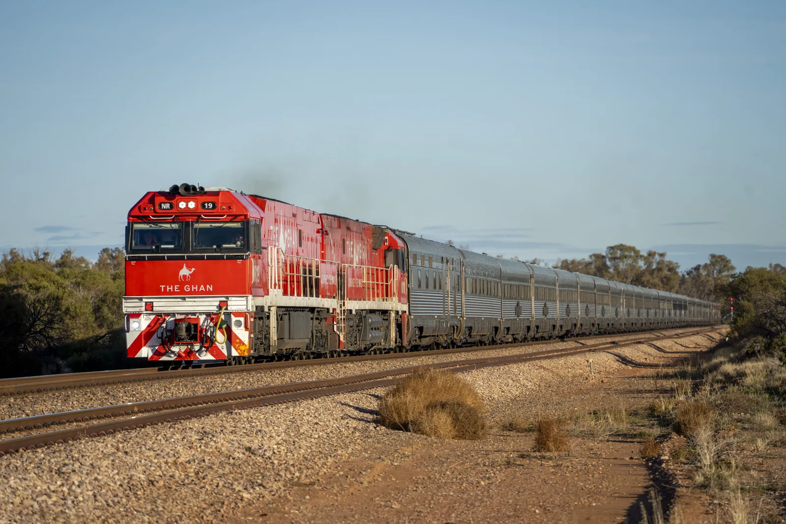 The Ghan passenger train crossing red Australian outback